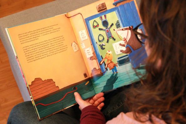 Katharina Mauder liest in einem ihrer Bilderbücher, um zu zeigen, dass Kinderbuchautor*innen nicht ohne Illustrator*innen auskommen.
